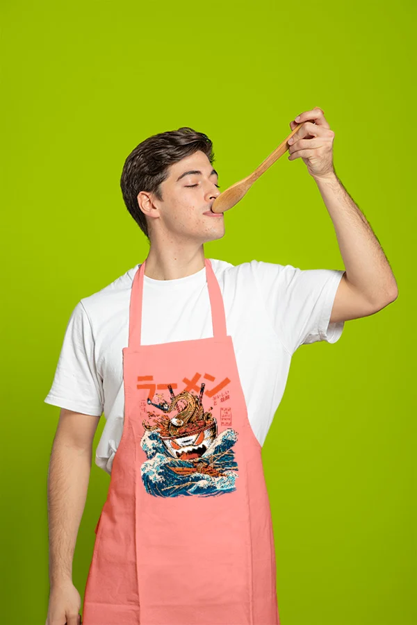 Chico con un delantal de noodles japoneses probando comida