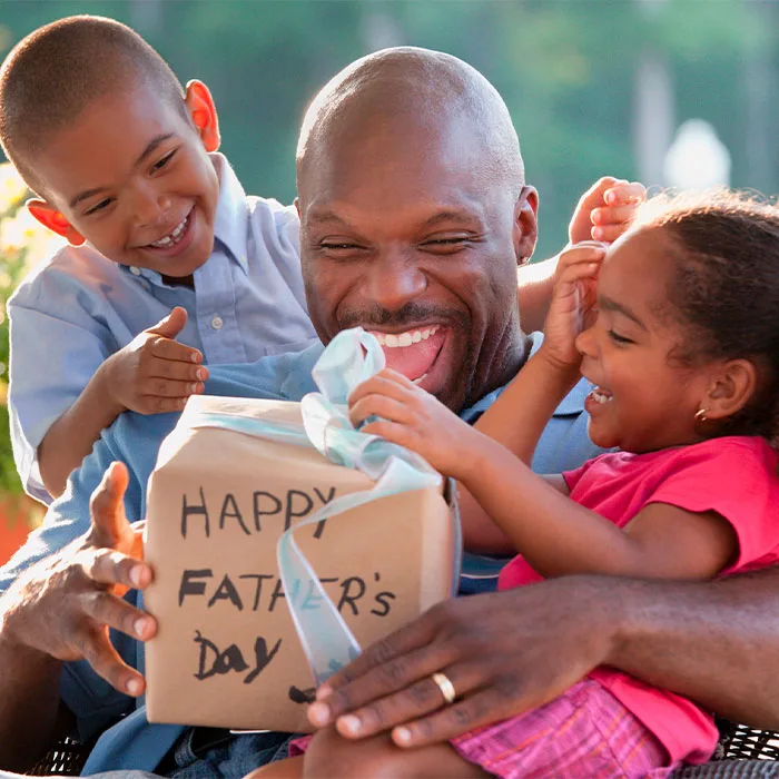 Hijos dándole un regalo a su padre