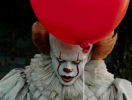 Pennywise mirando fijamente mientras sujeta un globo